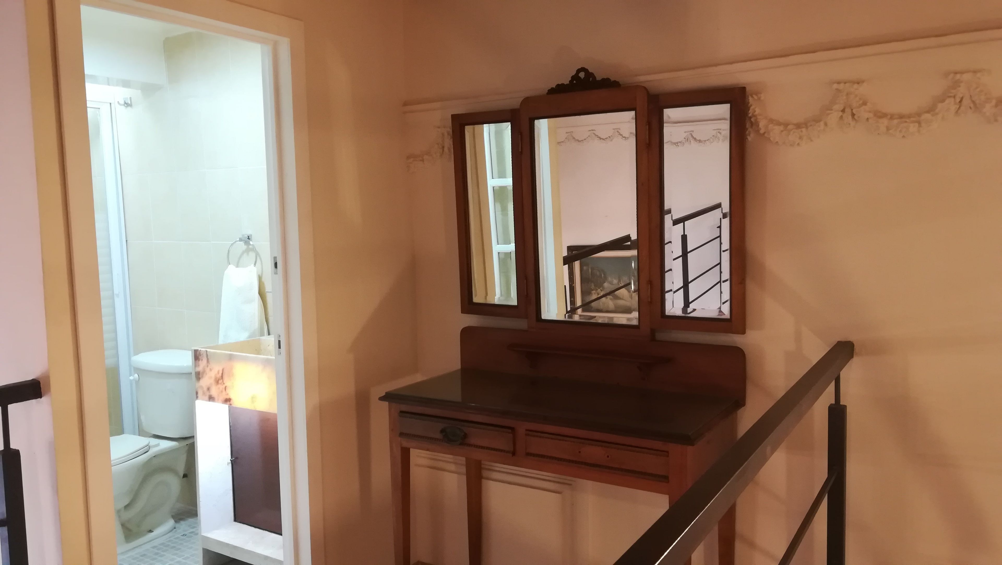 A bathroom with a toilet, a towel rack, and a mirror.