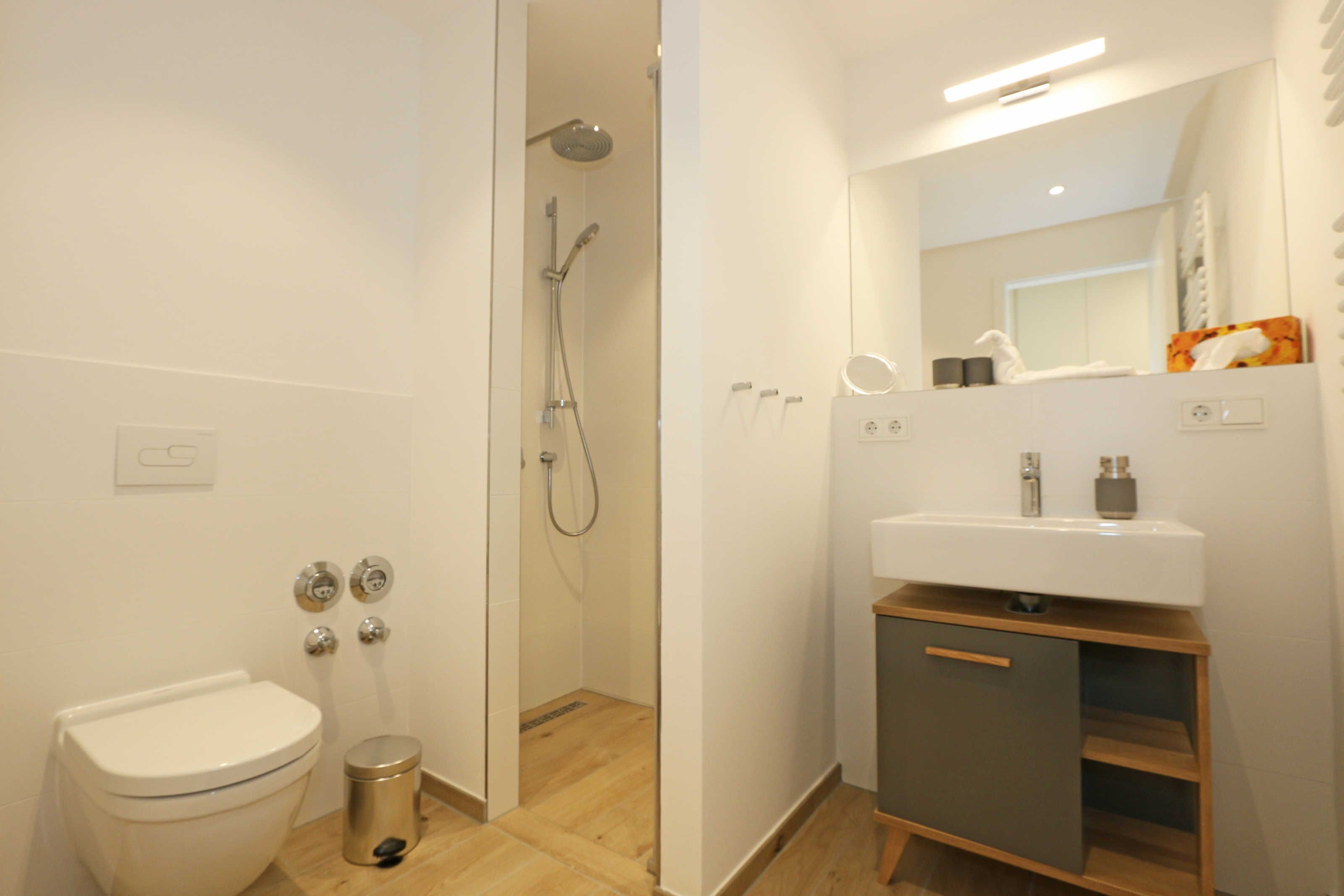 Une salle de bain moderne équipée de toilettes, d’un bidet et d’une douche.