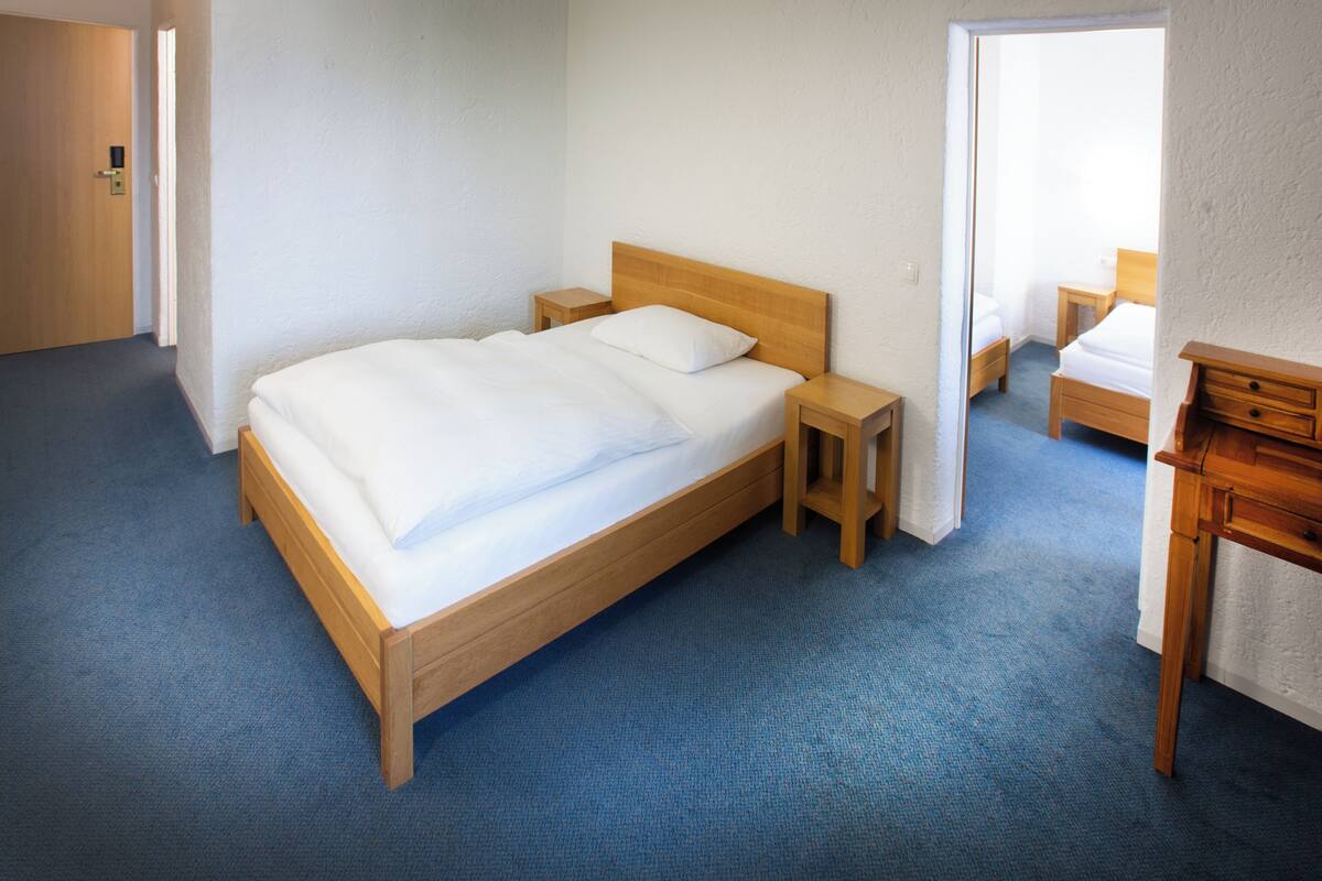 Ein Schlafzimmer mit einem hölzernen Bett, Nachttischen und einem Schreibtisch.