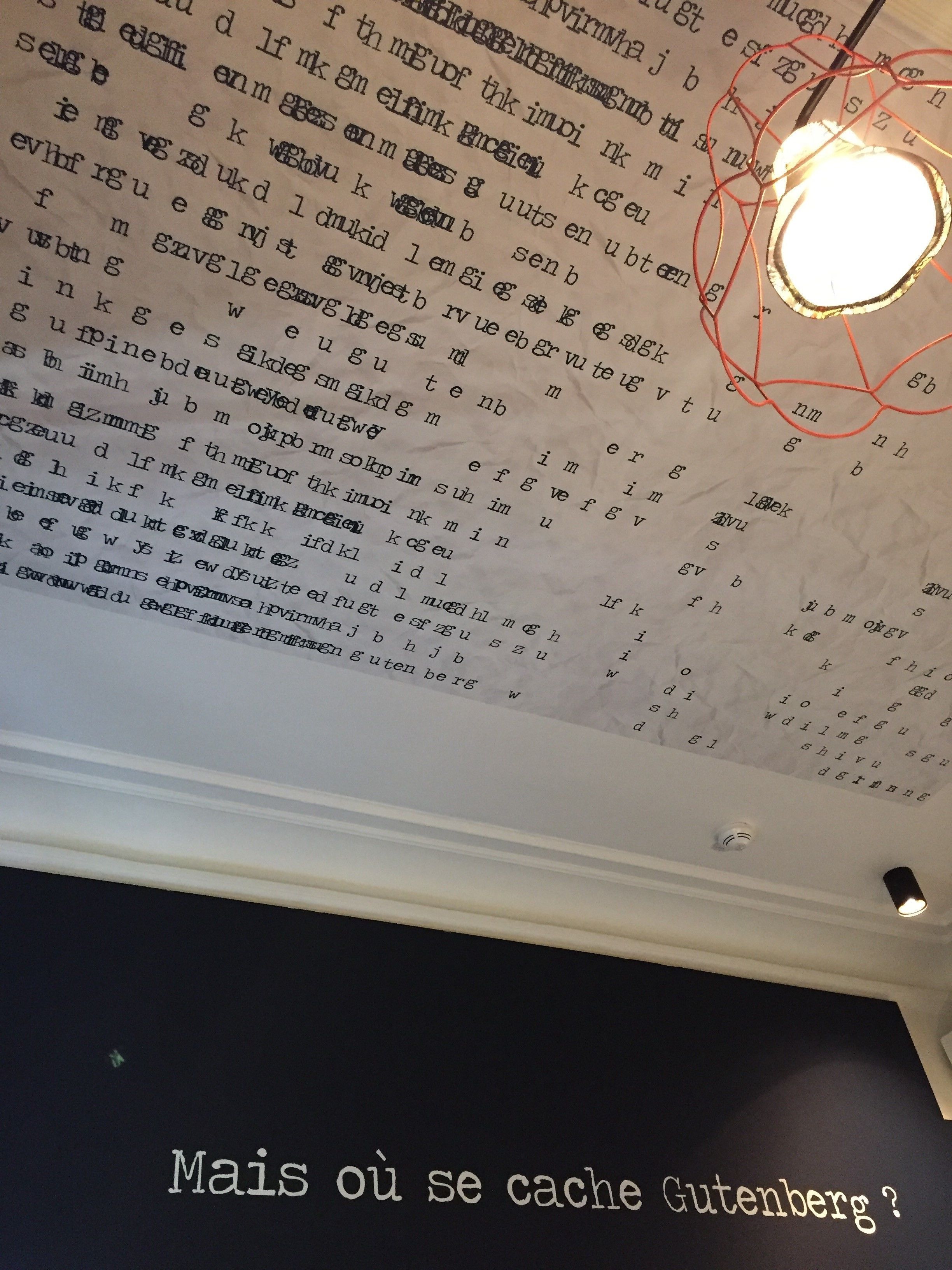 A ceiling with a light fixture and a wall with text.