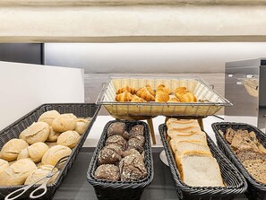 A buffet table with various bread and pastries. - Ibis Styles Chaves (Chaves)