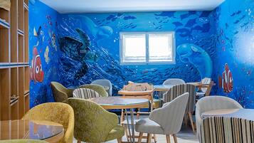 Een kamer met een muurschildering van de blauwe oceaan, houten meubels en een raam.