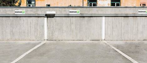 Un área de estacionamiento con barreras de hormigón y señales que indican espacios reservados.