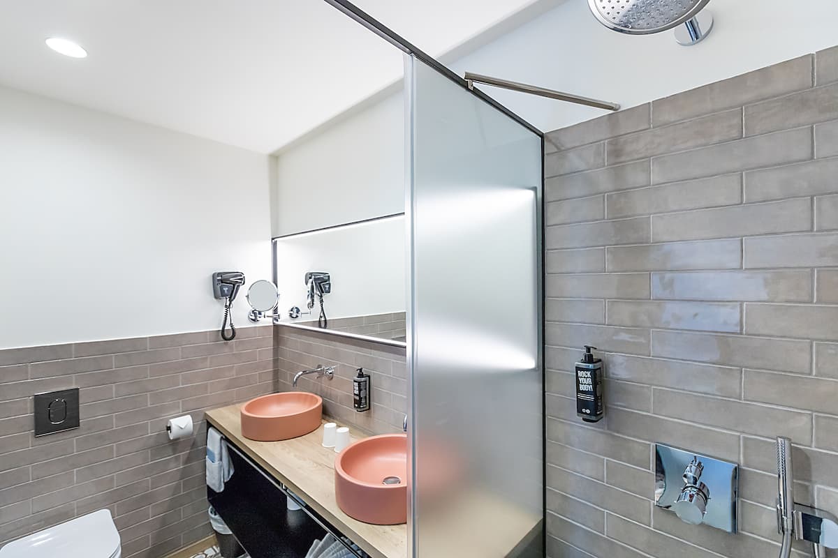 Habitación superior, 1 cama King size y sofá cama | Baño | Regadera, regadera tipo lluvia, amenidades de baño ecológicas