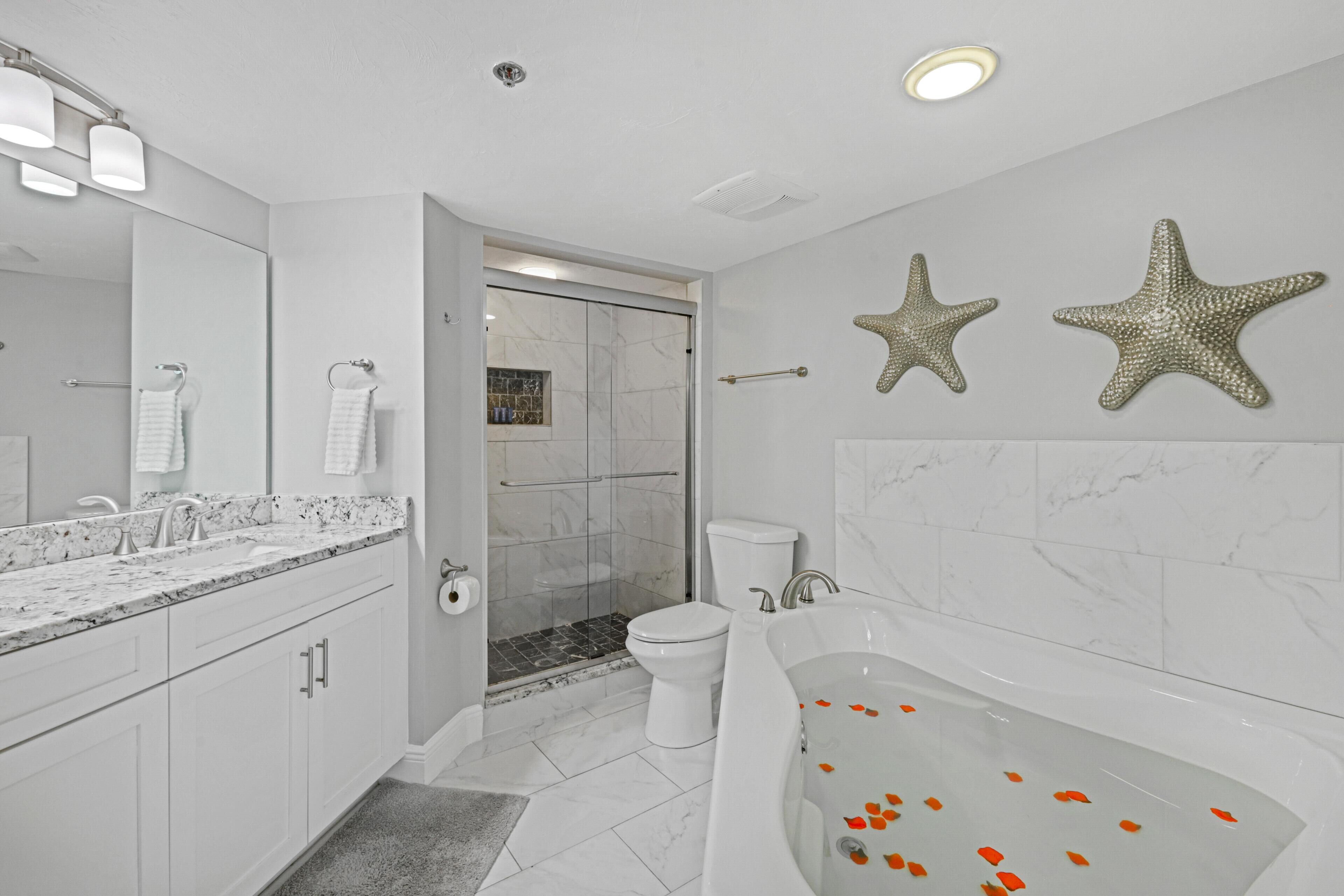 A modern bathroom with a large bathtub, a shower area, and a toilet.