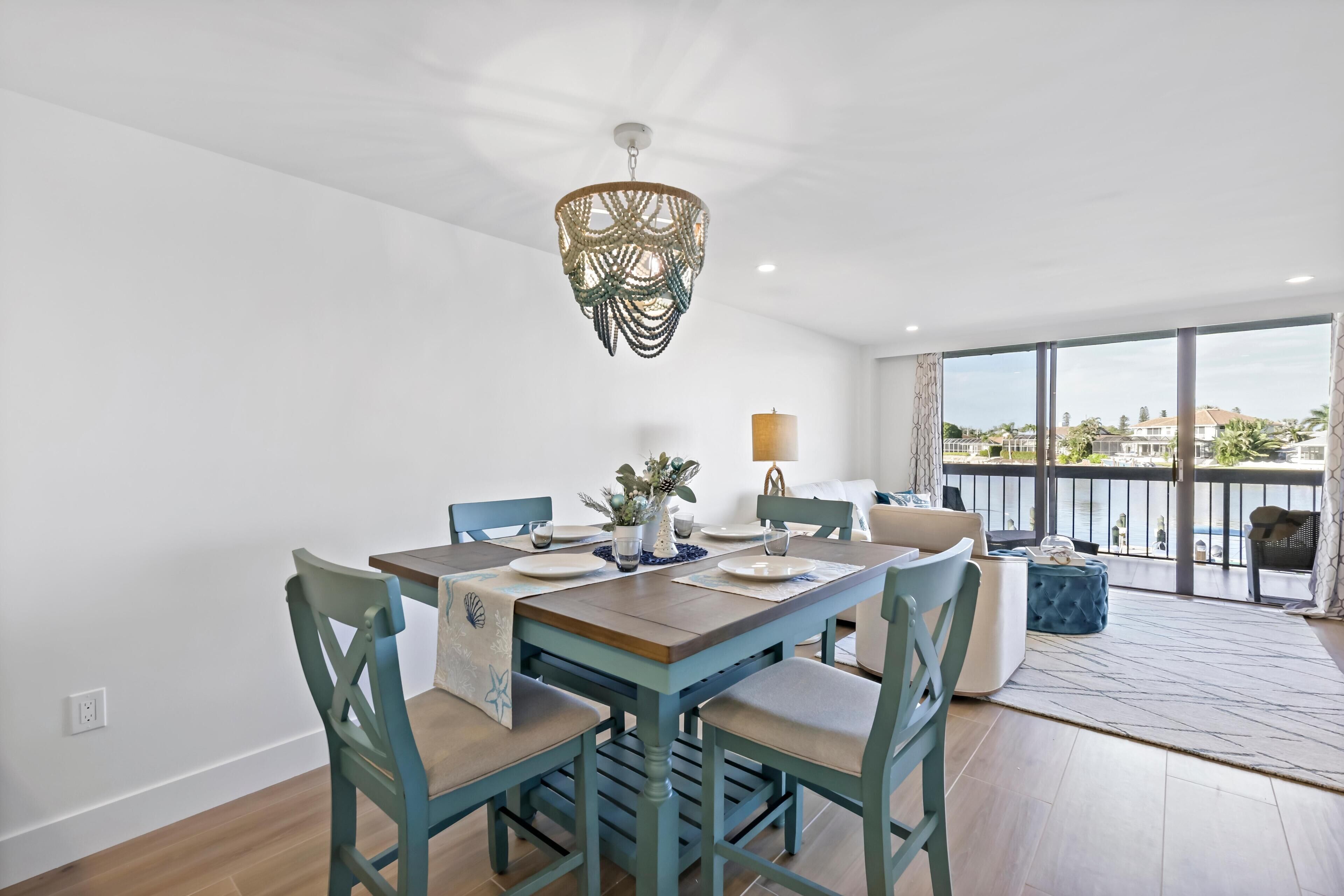 Un espace repas comprenant une table en bois, des chaises et un lustre.