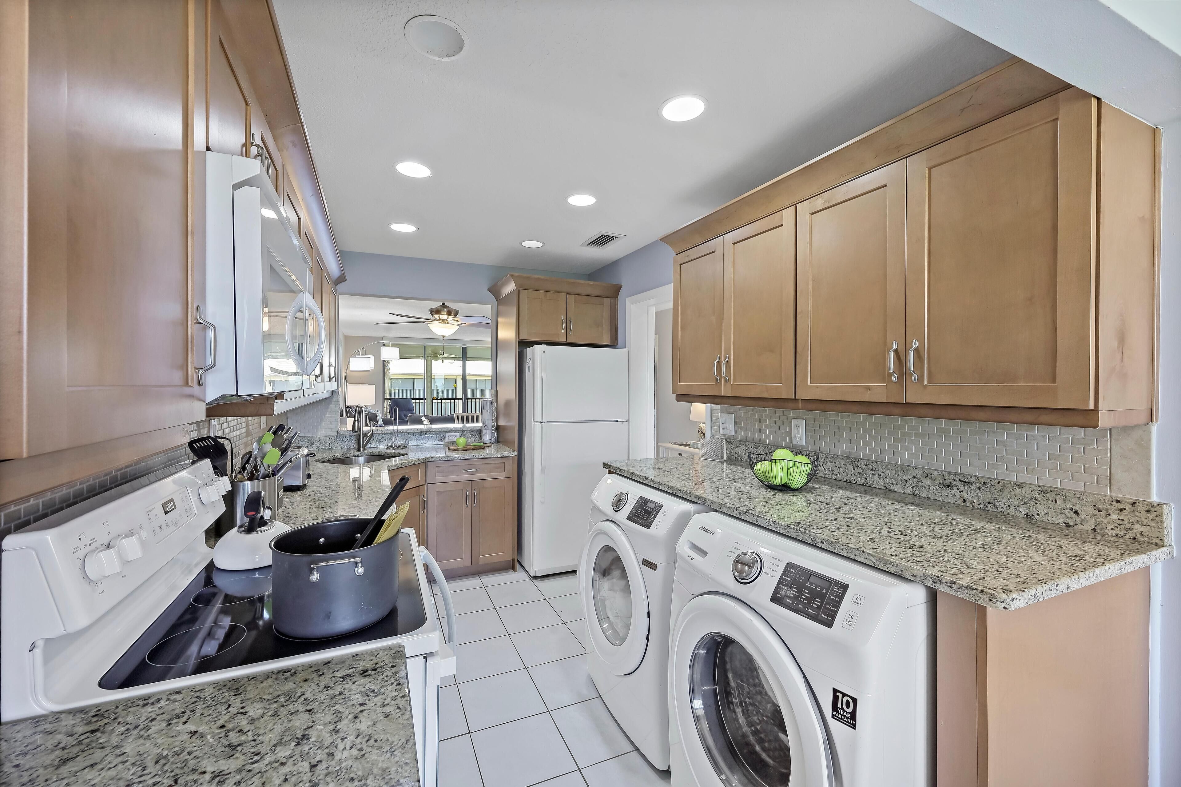 A kitchen with a stove, oven, microwave, and washing machine.