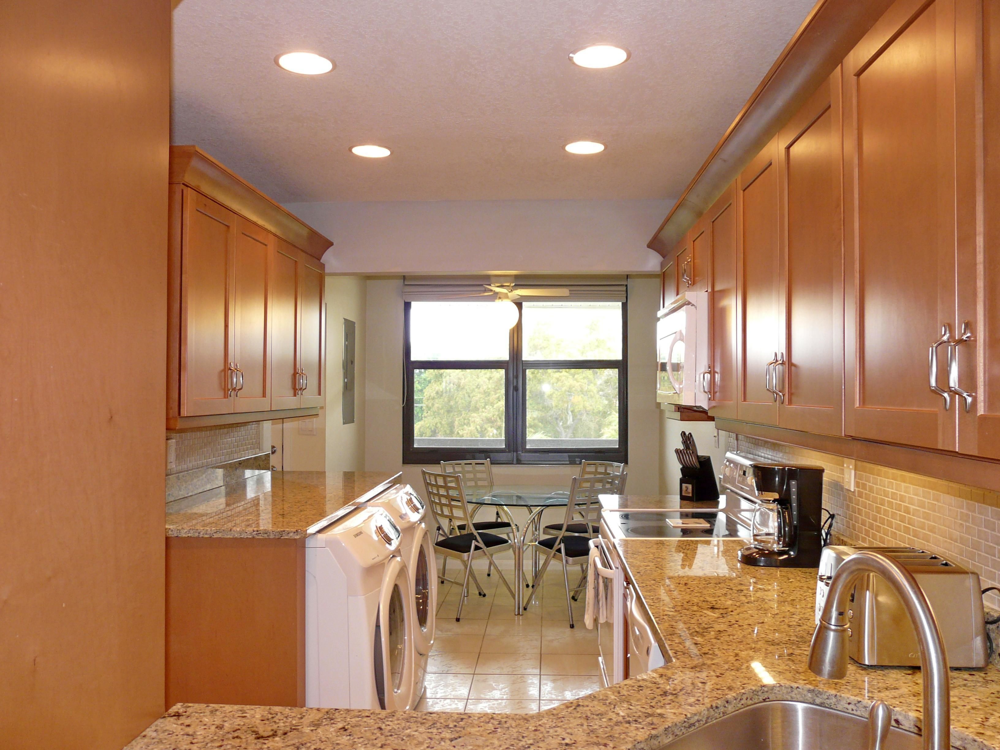 A modern kitchen with granite countertops, stainless steel appliances, and wooden cabinets.