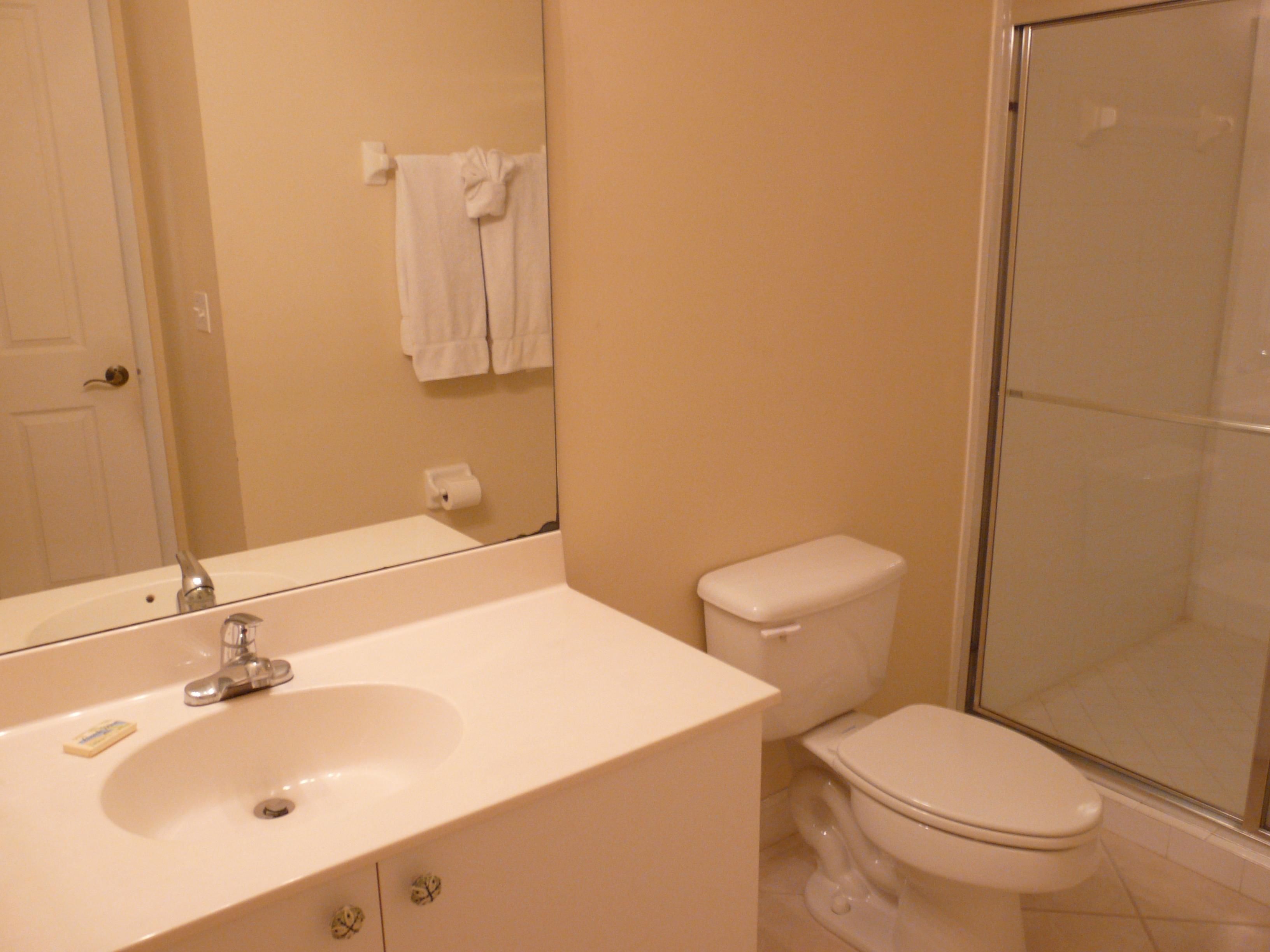 A bathroom with a sink, toilet, and a glass shower enclosure.