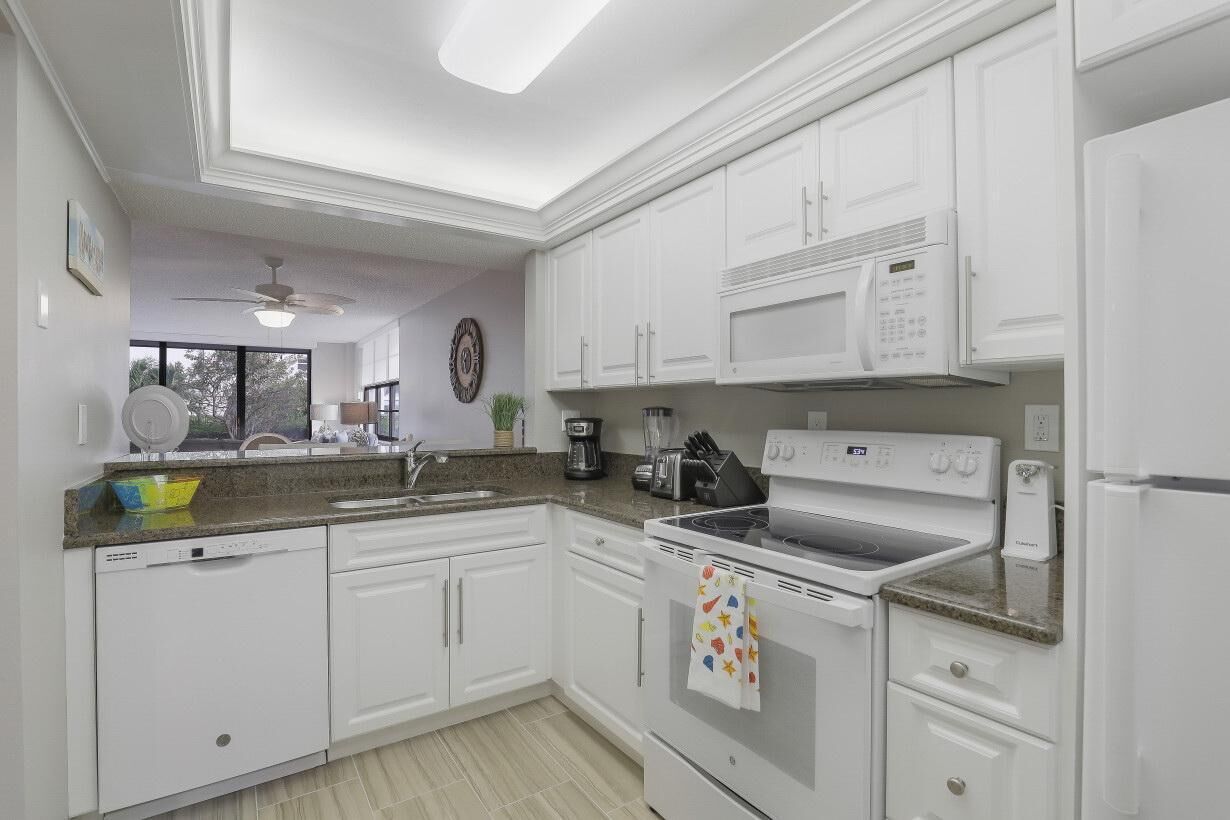A modern kitchen with white cabinetry, a built-in microwave, a stove, and a dishwasher.