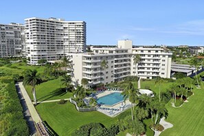 A hotel with multiple floors, a swimming pool, and well-maintained gardens.