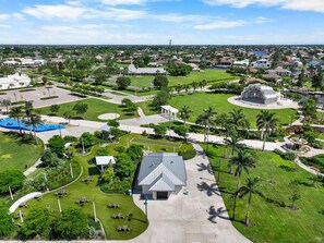 An aerial view of a park with a large building, pathways, and greenery. - Front Unit Facing Beach With Wraparound Balcony (Marco Island)