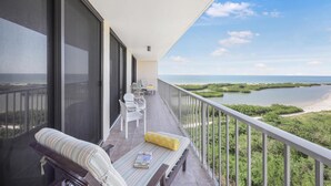 A balcony with a view of a beach and water. - Beachfront Condo With Pool and Ocean View From Balcony (Marco Island)