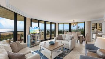 A spacious living room with a large window, a television, and a coffee table.