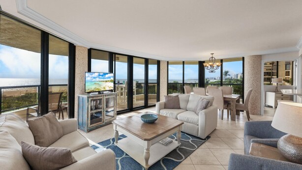 A spacious living room with a large window, a television, and a coffee table.