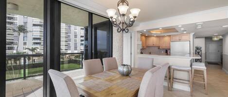 A modern dining area with a wooden table, cushioned chairs, and a decorative centerpiece.