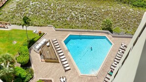 Une piscine dotée de chaises longues et d’une terrasse ensoleillée.