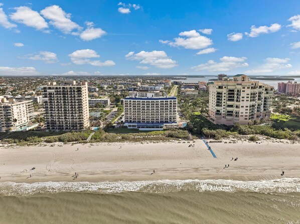 A coastal cityscape with high-rise buildings, a beach, and a clear sky. - Unique Beachfront Condo With Panoramic Beach View (Marco Island)