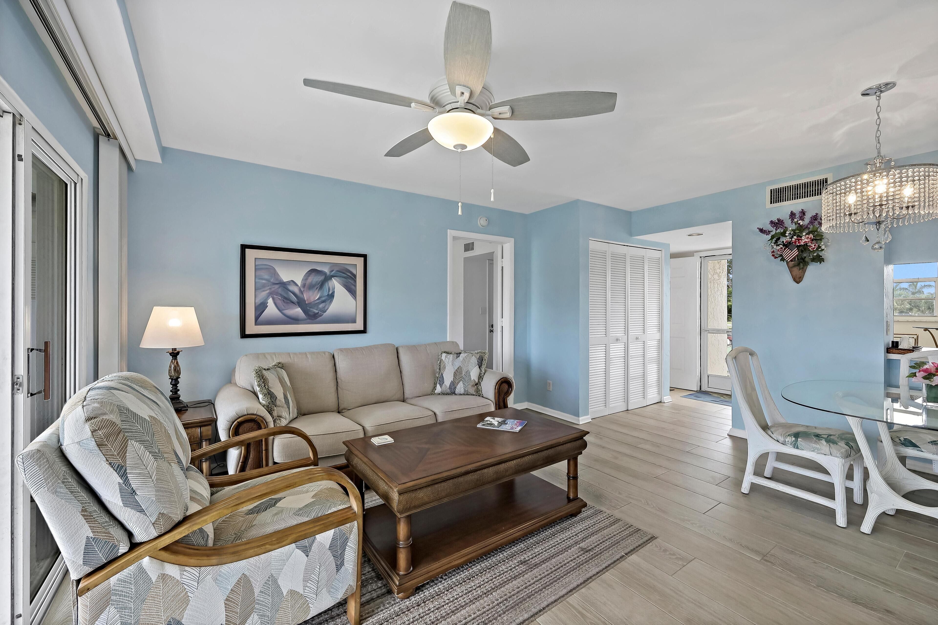 A living room with a ceiling fan, a wooden coffee table, a sofa, and a dining table with chairs.