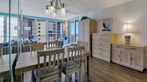 A modern kitchen with wooden furniture, a chandelier, and a view of a cityscape.