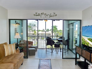 Relax in this stylish living room with a sofa, flat-screen TV, and balcony access.