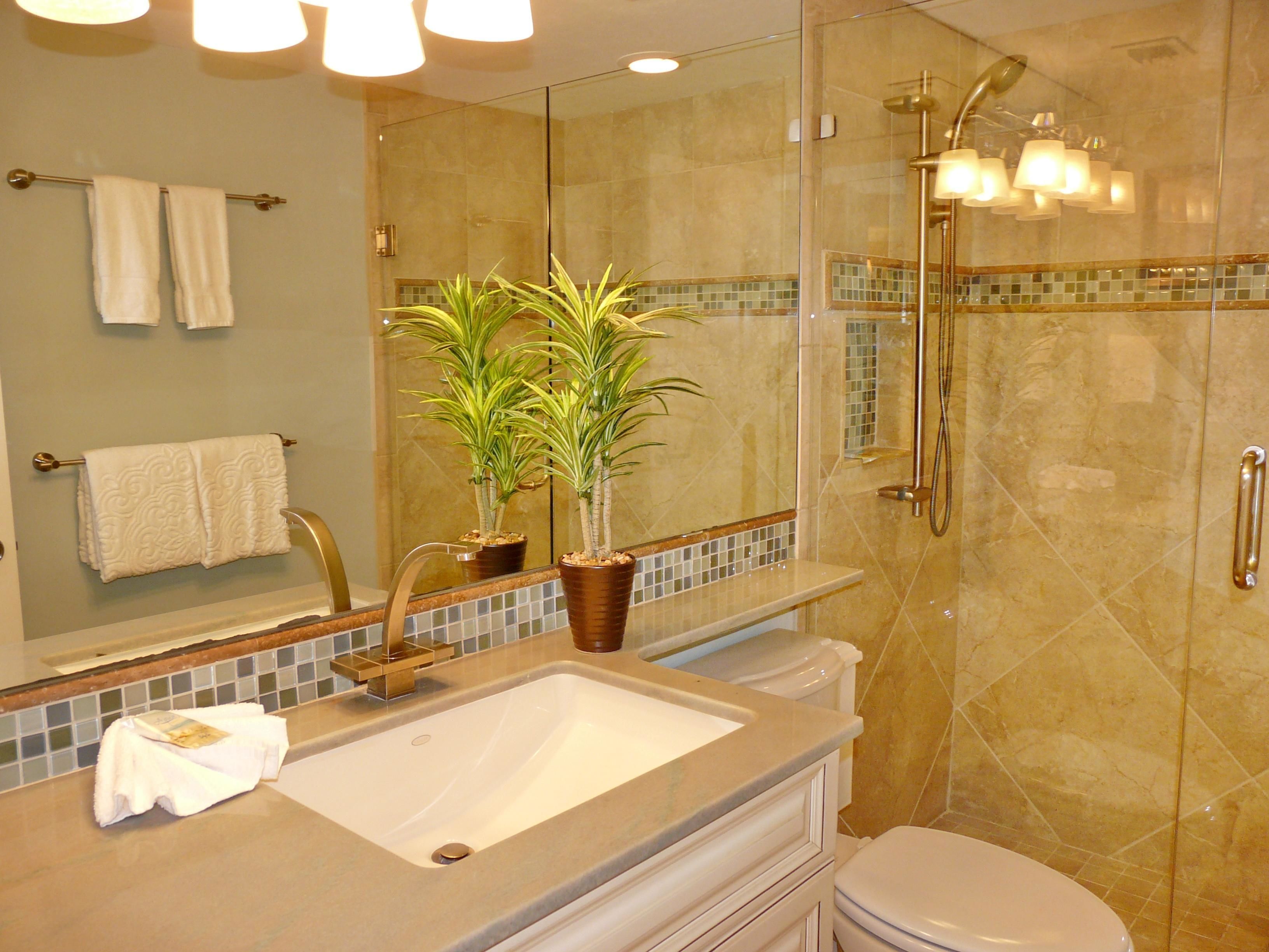 A bathroom with a sink, mirror, towel rack, potted plant, and shower.