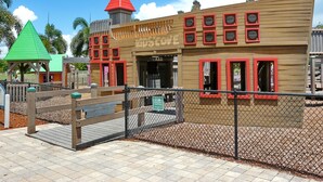 A wooden building with red-framed windows and a green roof. - Cozy Beachfront Condo With Pool and Tennis Courts (Marco Island)