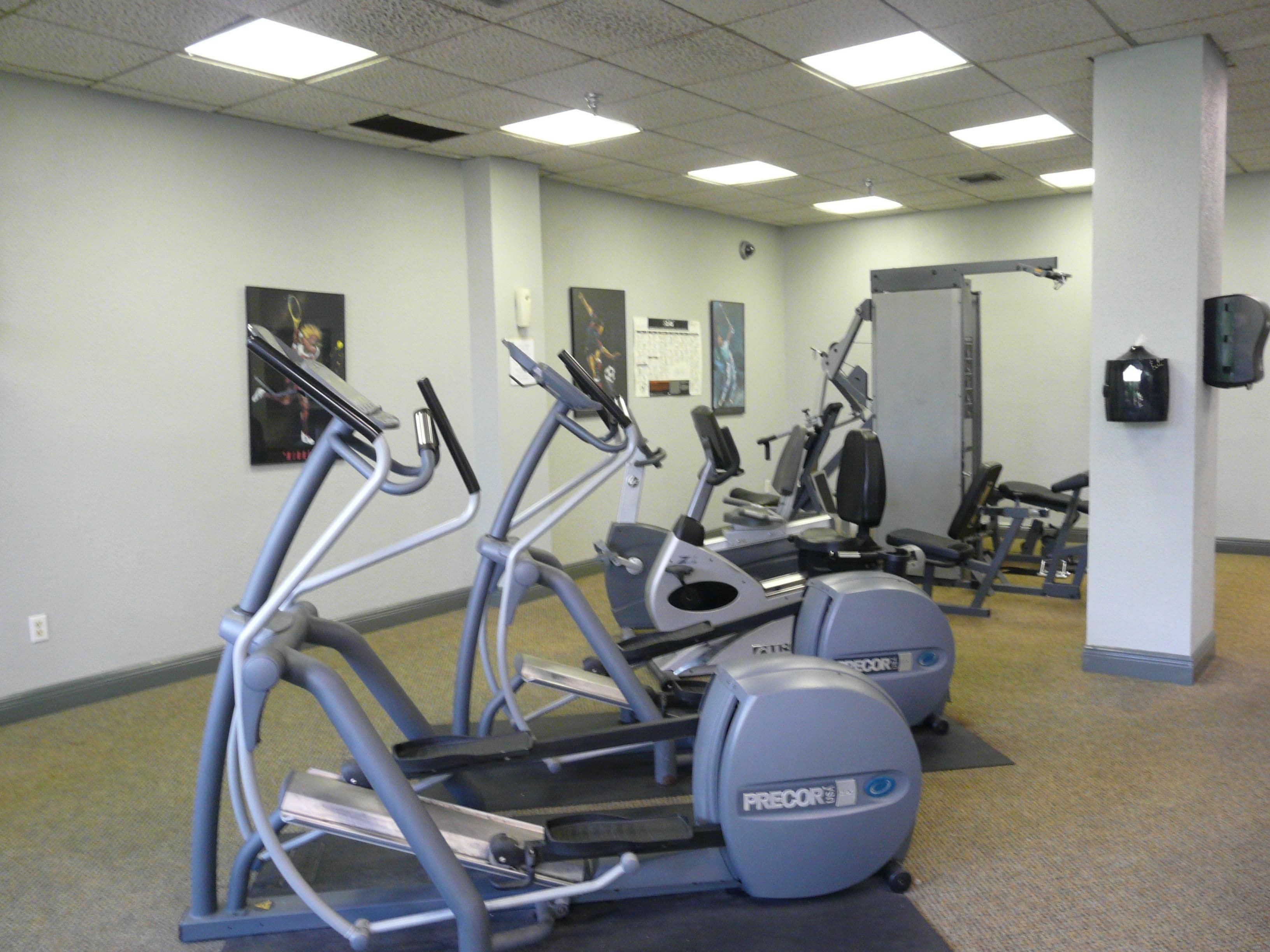 Un gimnasio con bicicletas estáticas, cintas de correr y máquinas de pesas.