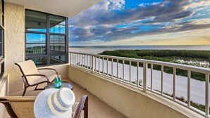 A balcony with a view of a river and a cloudy sky. - Beachfront Condo With Pool and Dazzling Ocean View (Marco Island)