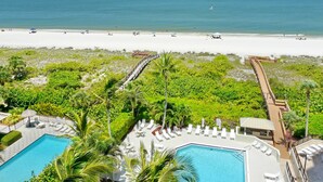 A resort with a pool, beach access, and a boardwalk. - Cozy Beachfront Getaway With Pool and spa (Marco Island)