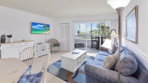 A modern living room with a sofa, coffee table, and dining area.