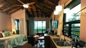 Una habitación con cama, escritorio y ventanas amplias.
