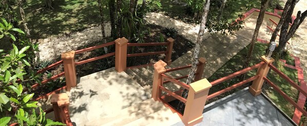 A wooden staircase with a red railing leading to a higher level. - Villa Cayo - Adults Only (San Ignacio)