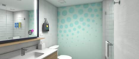 A modern bathroom with a white sink, mirror, and toilet. There is a towel rack with folded towels and a trash can.