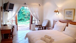 A hotel room with a bed, a chair, a desk, a television, and a view of the outdoors. - Polokwane Place (Polokwane)