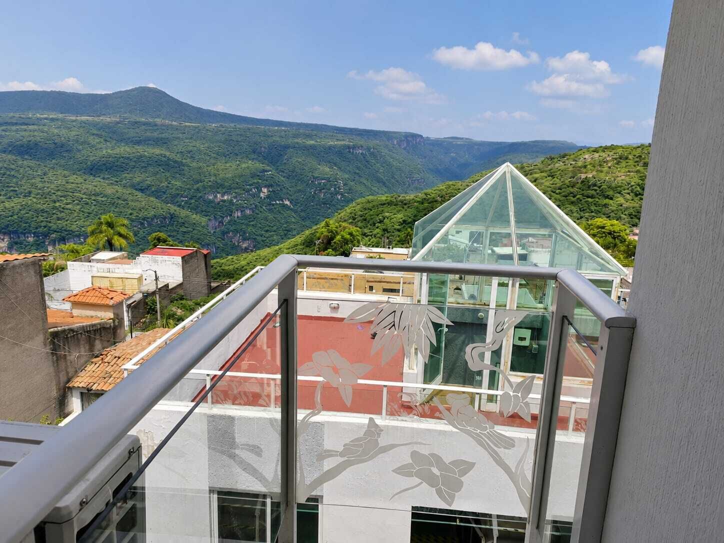 A balcony with a view of a mountainous landscape.