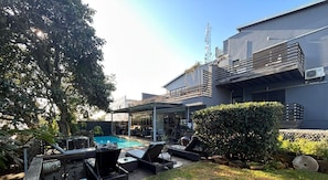 A modern house with a swimming pool, outdoor seating, and a covered patio area. - Sea Dreams Guesthouse (Ballito)