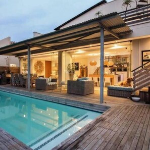 Una piscina al aire libre, sillones reclinables de piscina