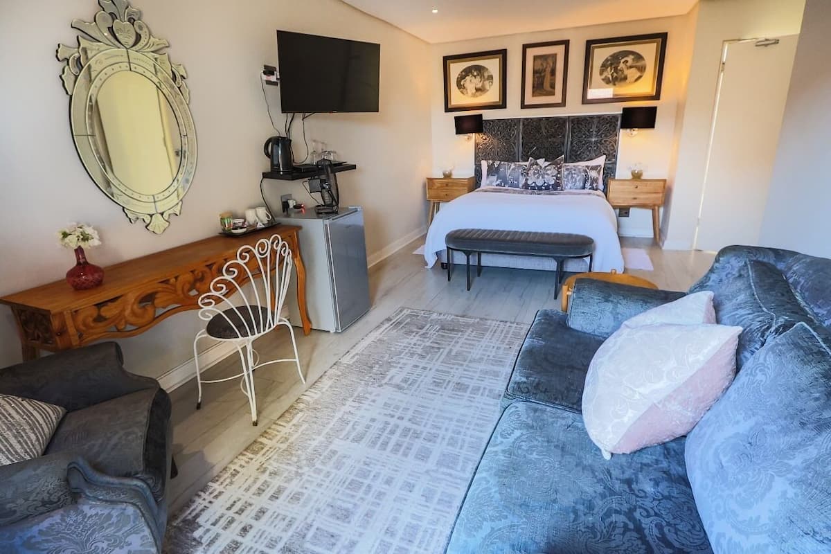 A bedroom with a bed, a TV, a desk, and a chair.