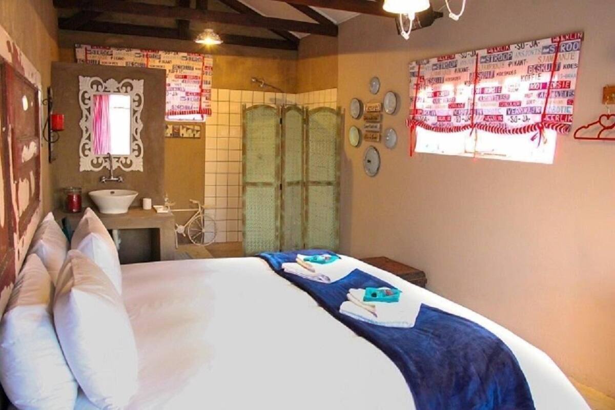 Ein Hotelzimmer mit Bett, Waschbecken, Spiegel und Dusche.