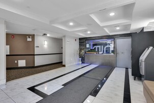 Un moderno vestíbulo de hotel con un mostrador de recepción, un área de espera y una recepción.
