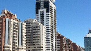 A row of high-rise residential buildings with multiple balconies and a clear blue sky. - Obispo Oro Flat ZX1 (Córdoba)