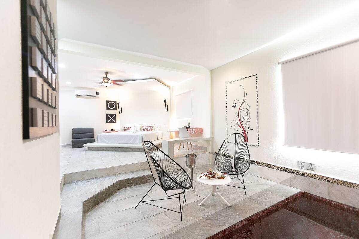 A modern interior with a seating area, a staircase, and a decorative wall.