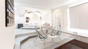Un interior moderno con una zona de estar, una escalera y una pared decorativa.