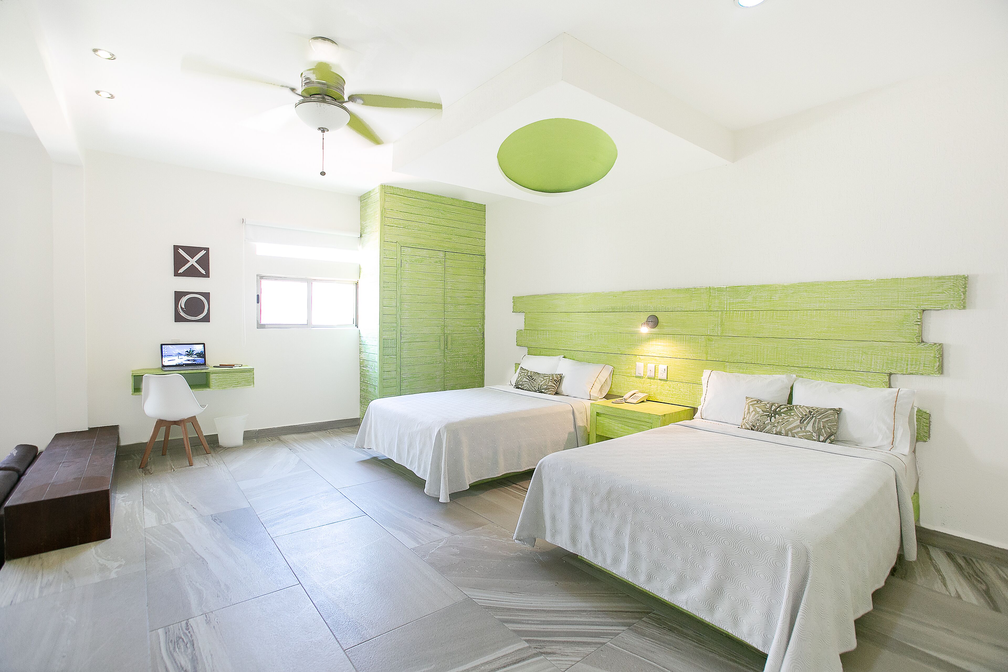 Habitación de hotel con dos camas, un escritorio y una silla.