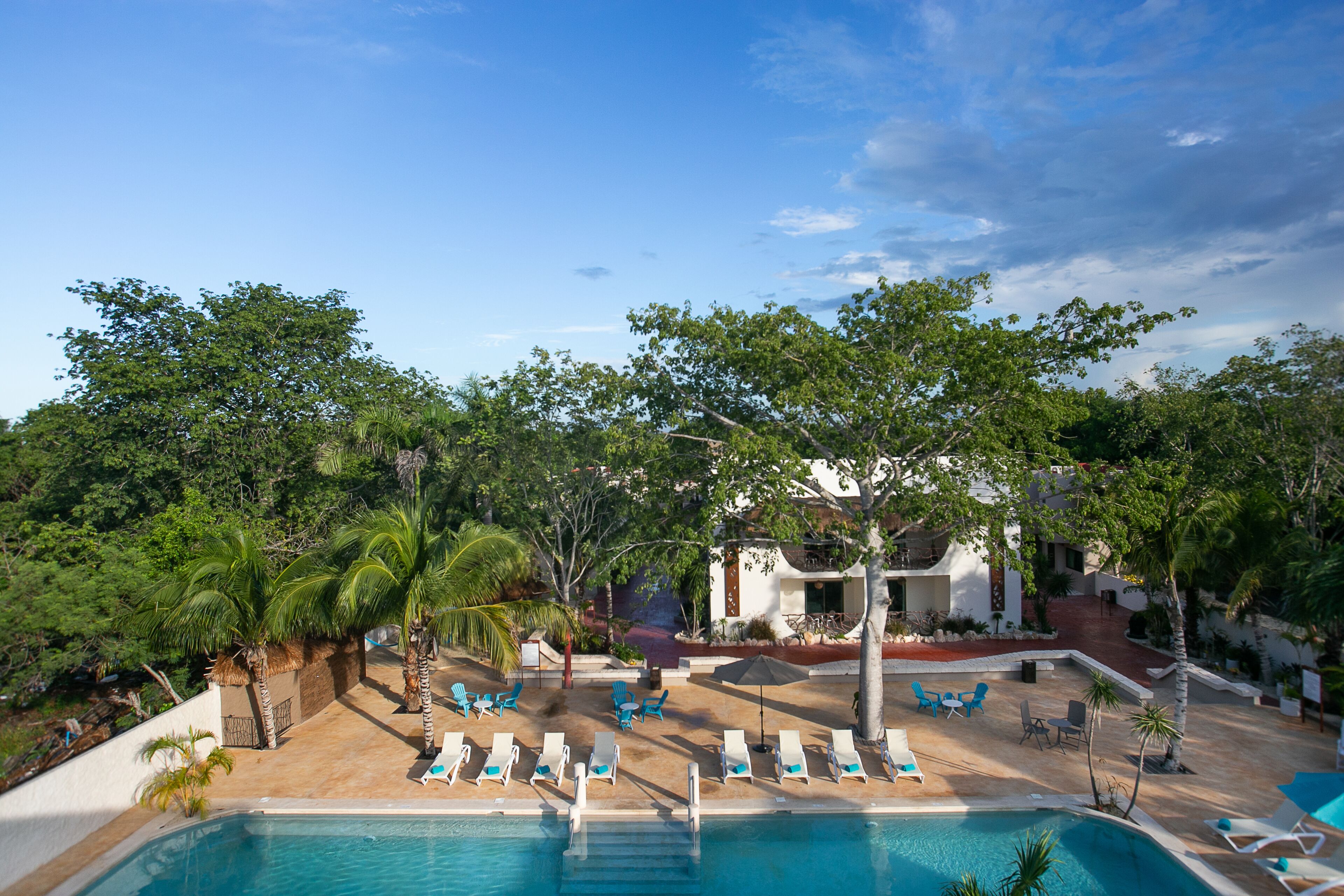A pool area with lounge chairs and a building in the background.