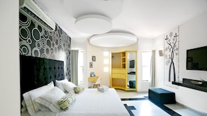 Una habitación de hotel moderna con una cama grande, un escritorio, un armario y una televisión.
