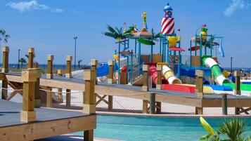A water park with a pool, slides, and play structures.