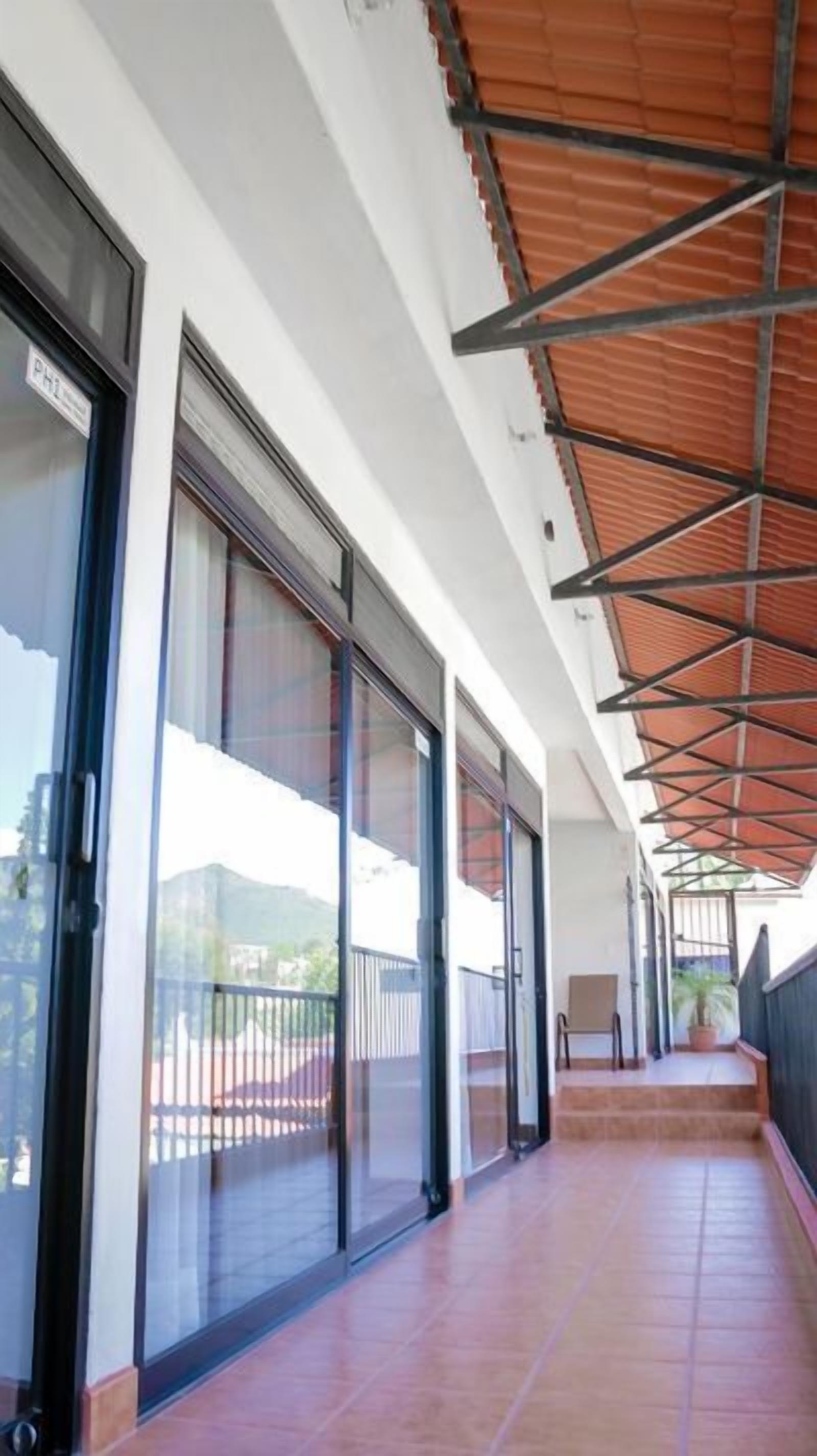 A covered corridor with sliding glass doors leading to a balcony.