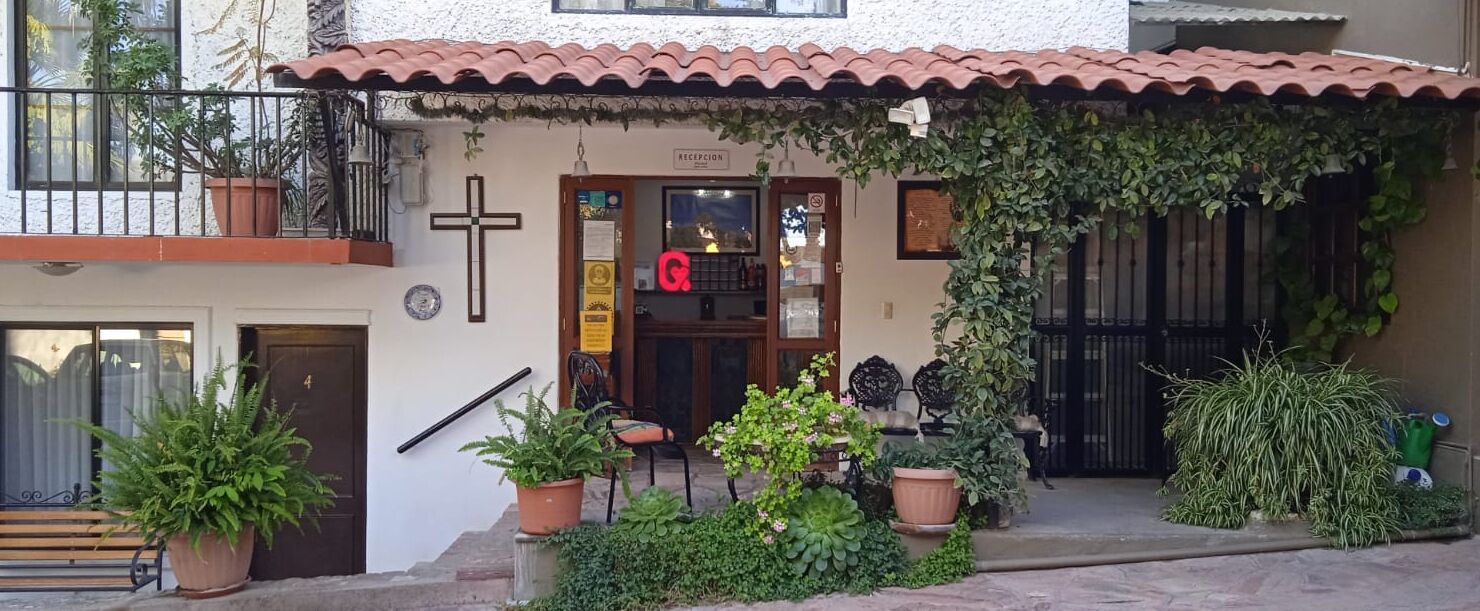 A building with a tiled roof, a cross, and a reception sign.